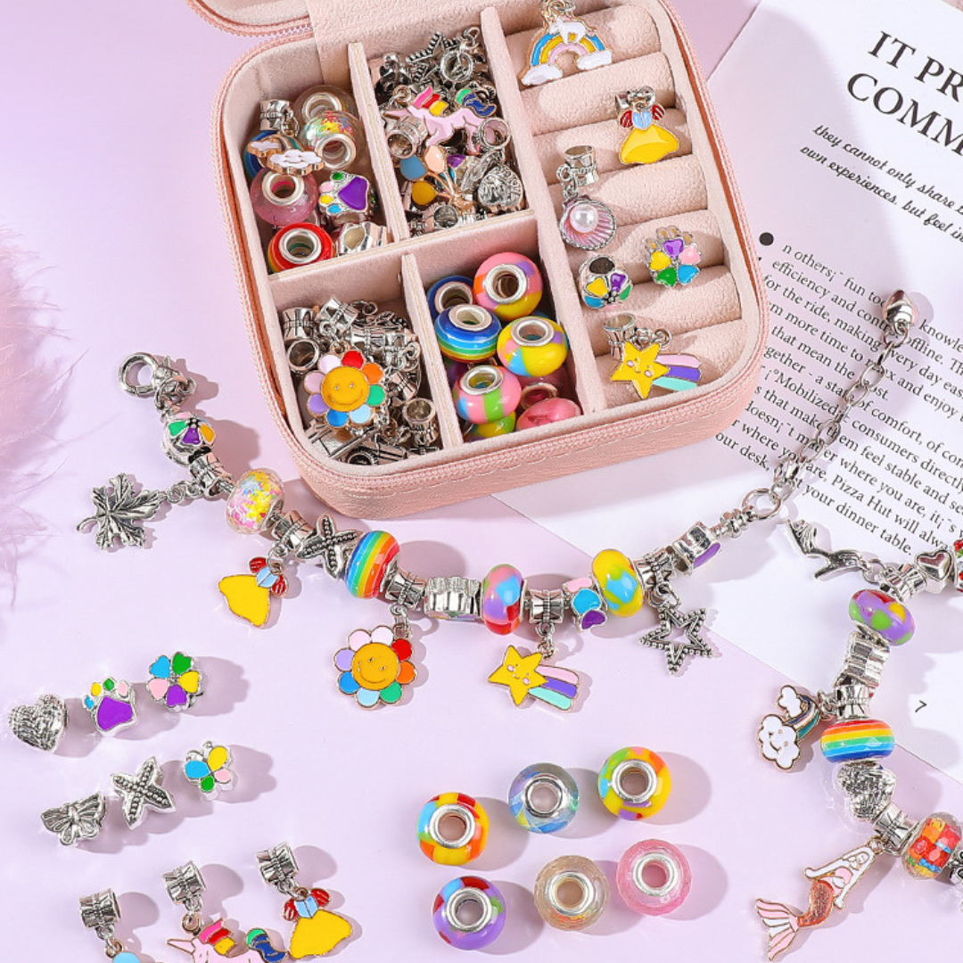 Πολύχρωμο DIY σετ κατασκευής βραχιολιού για παιδιά, με ζωντανές χάντρες, ελαστικό κορδόνι, γούρια και φυλλάδιο οδηγιών, σε φωτεινό φόντο.